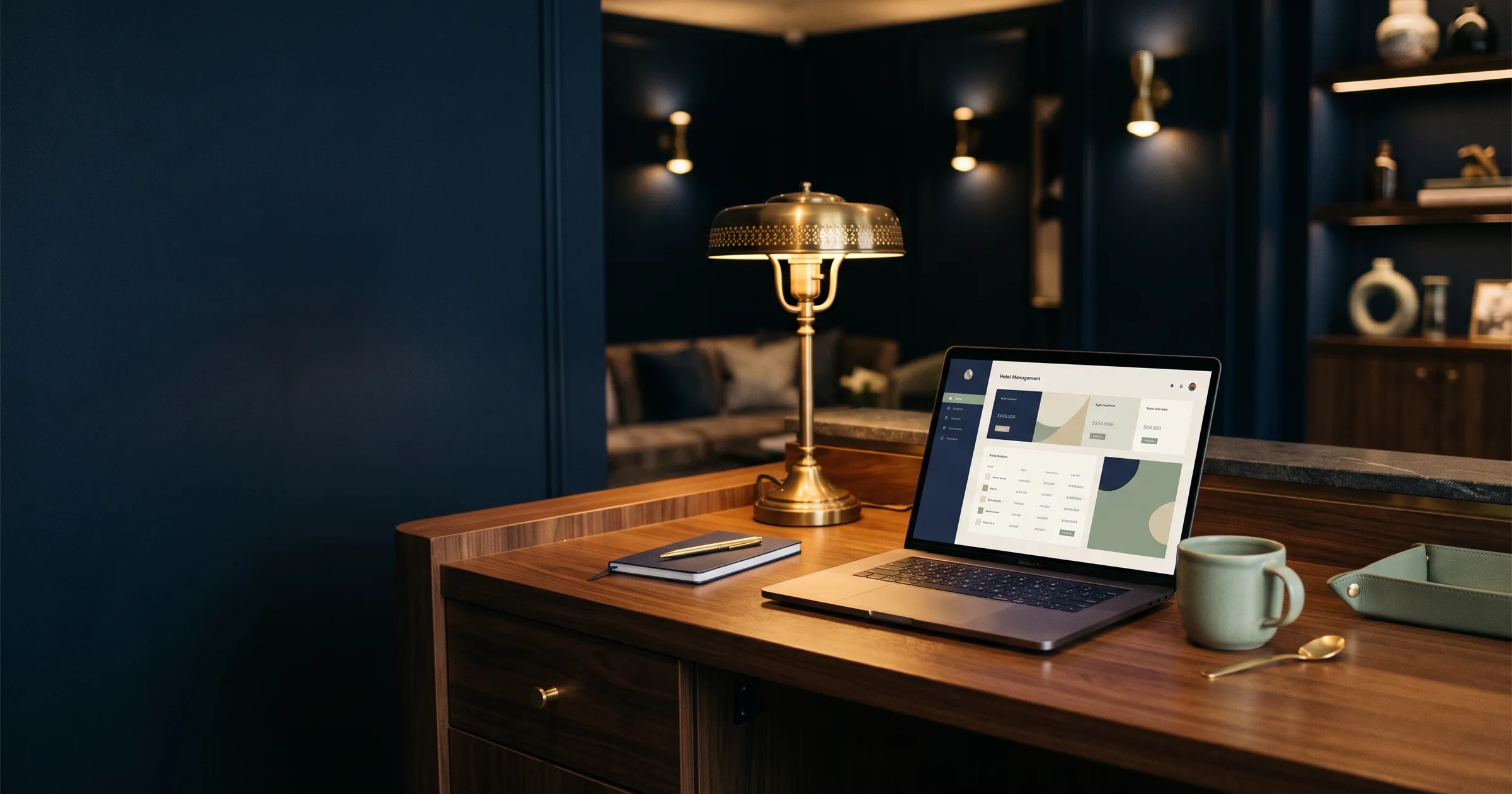 Hotel manager desk with open laptop showing a calm dashboard and brass lamp